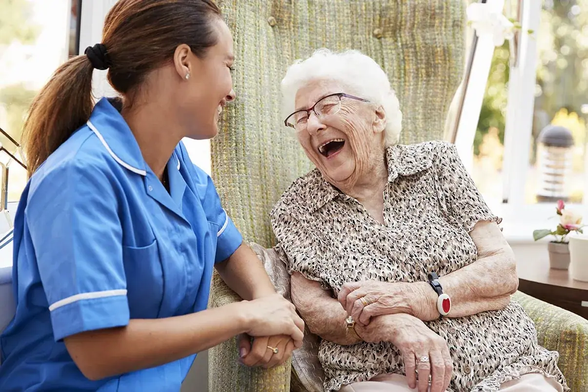 A carer laughing with an elderly woman